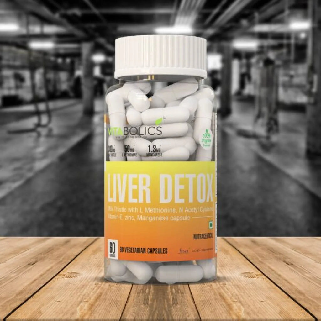 Bottle of 'Liver Detox' capsules on a wooden surface with a gym background